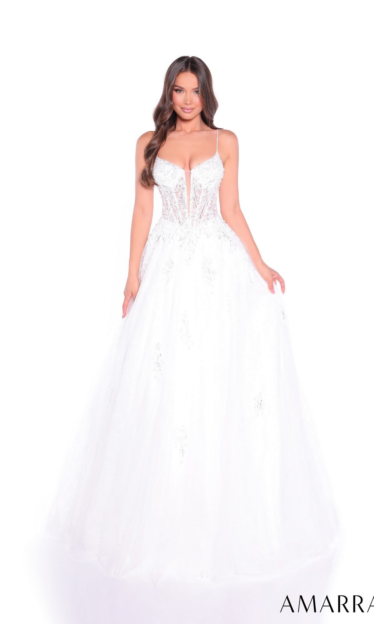 A woman wears the Amarra 89425 long prom dress, a white glitter tulle ball gown with beaded appliques, fitted bodice, spaghetti straps, and voluminous skirt, standing against a white background.
